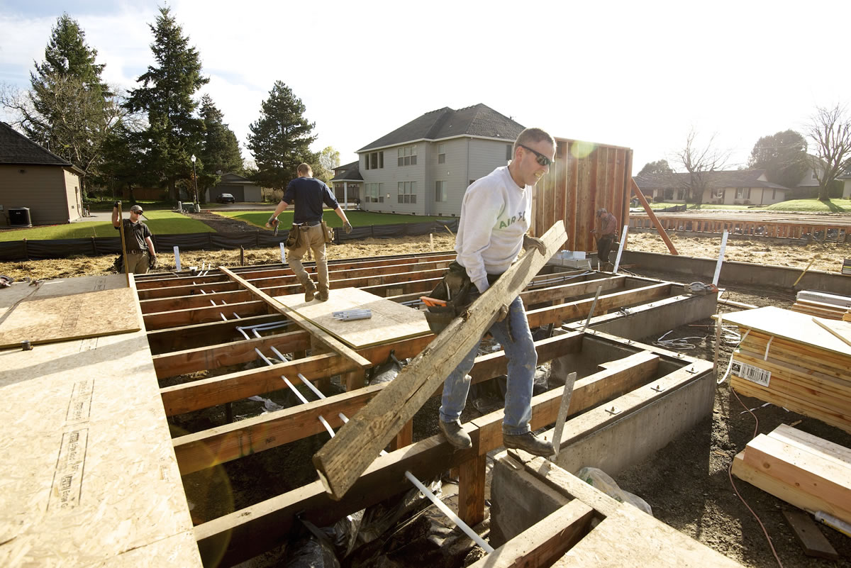 Curtis Karlsen of Pahlisch Homes helps build a house last month in Vancouver.