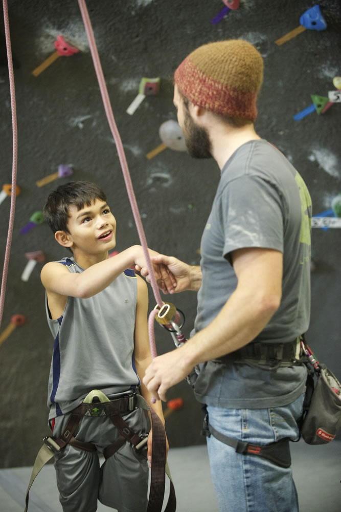 Bryan Caldwell, a climbing instructor at The Source Climbing Center, congratulates Kai Cathcart, 10, of Camas on and October climb at The Source in Vancouver.