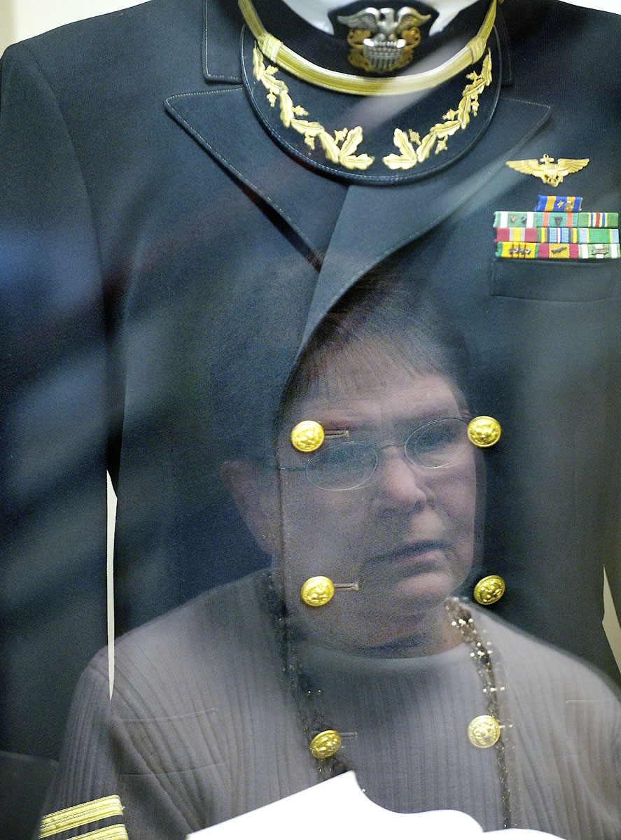 Gwen Hall Davis, the sister Harley Hall, is reflected in the glass of a display honoring the missing Navy fighter pilot. Rather than call it an anniversary, she always refers to Jan.