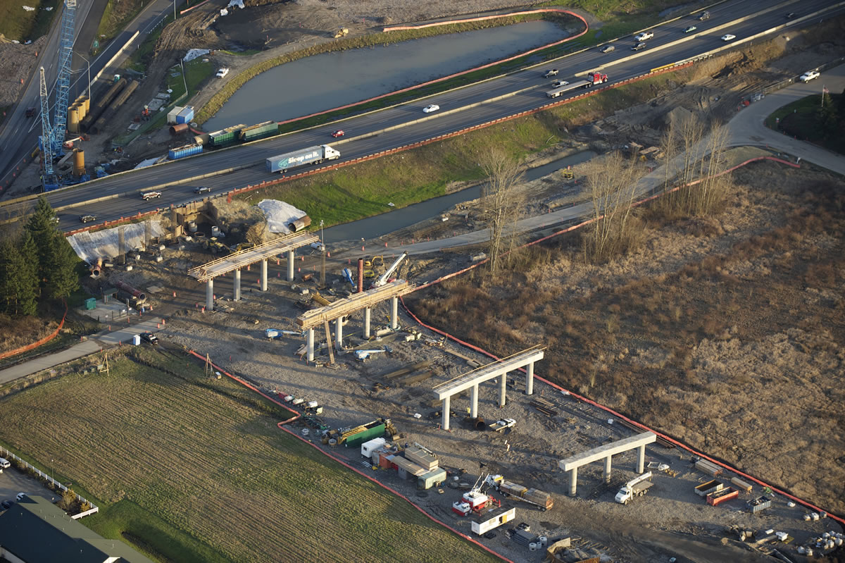 Contractors for the Washington State Department of Transportation are transforming the look of the area where Interstates 5 and 205 join, in the Salmon Creek area north of Vancouver. Piers that will carry the new Northeast 139th Street overpass over the traffic lanes are under construction on the west side of Interstate 5, in the foreground of this photo, which looks east. The storm drainage pond beyond the highway on the left edge of the photo is on the site of the old Salmon Creek Park &amp; Ride lot, which was closed for wetlands mitigation. The $133 million project will offer motorists an east-west alternative to Northeast 134th Street in the busy corridor that includes Washington State University Vancouver, Legacy Salmon Creek Medical Center, the new Park &amp; Ride, and the Salmon Creek Community Library.