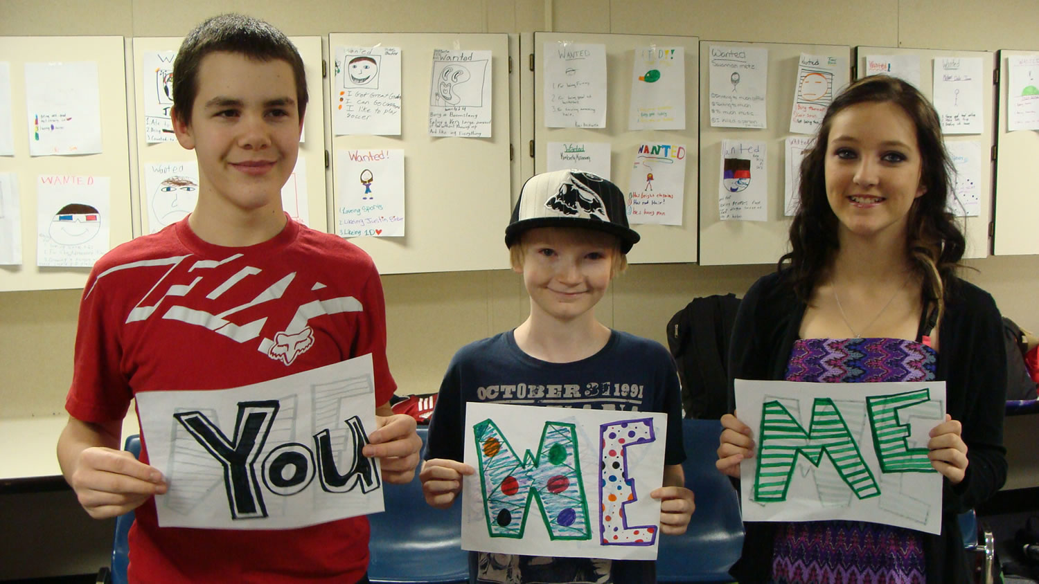 Jemtegaard Middle School students (left to right) Corey Barton, Casey Schulenbarger and Kim Kanning hold signs which accompany a poem for their anti-bullying performance, based on the T.V.
