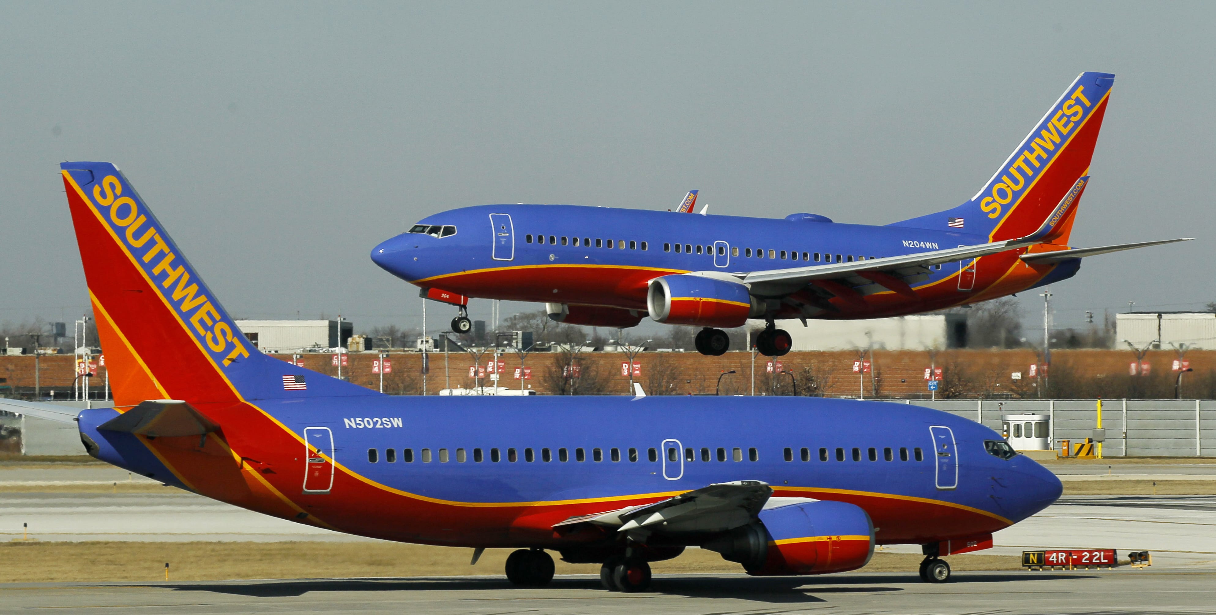A Southwest Airlines Boeing 737 waits to take off at Chicago's Midway Airport as another lands.