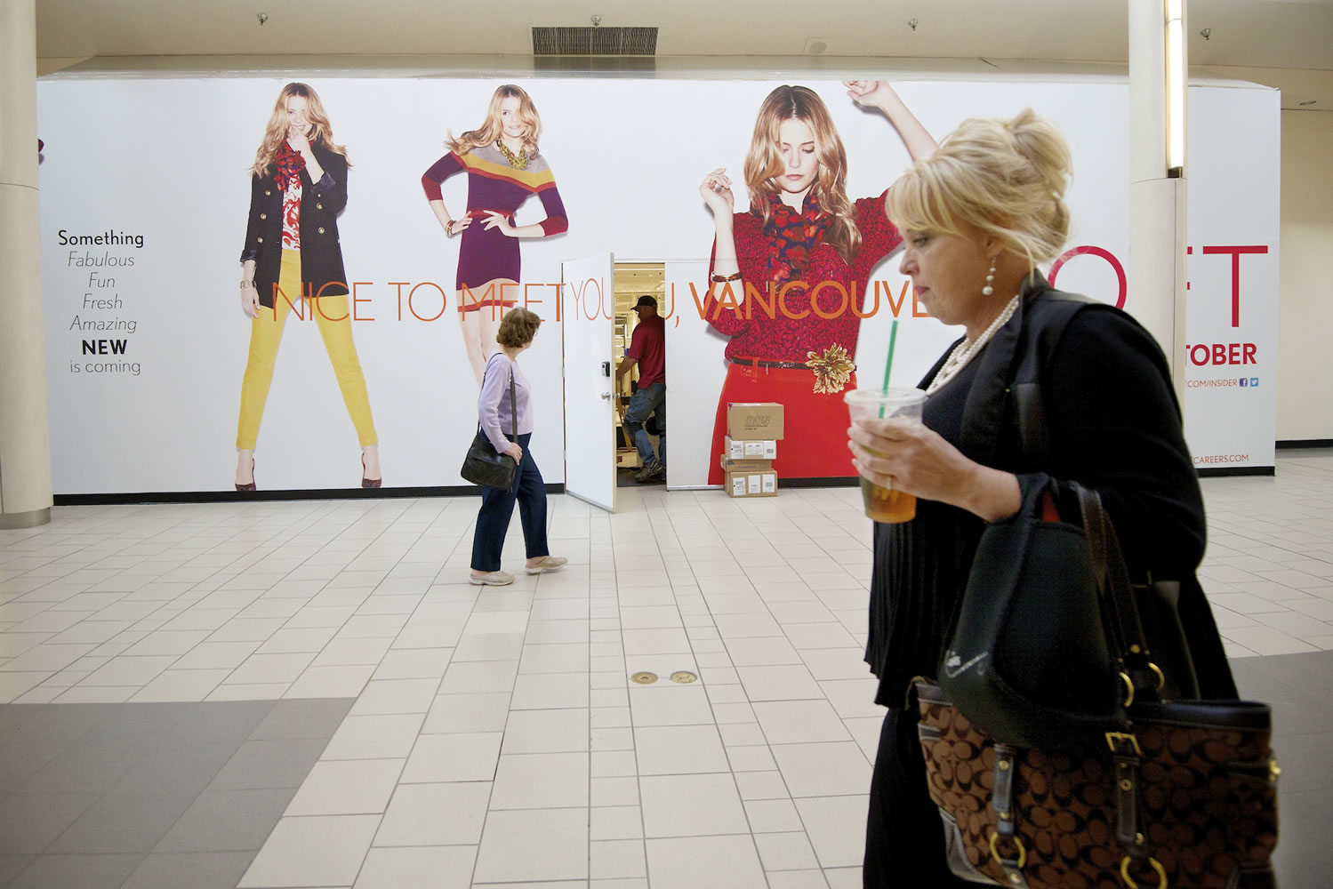 Shoppers walk past a temporary store front at Westfield Vancouver mall, which opened a slate of new stores and a new Cinetopia multiplex as part of its multi-million dollar remodel in 2012.