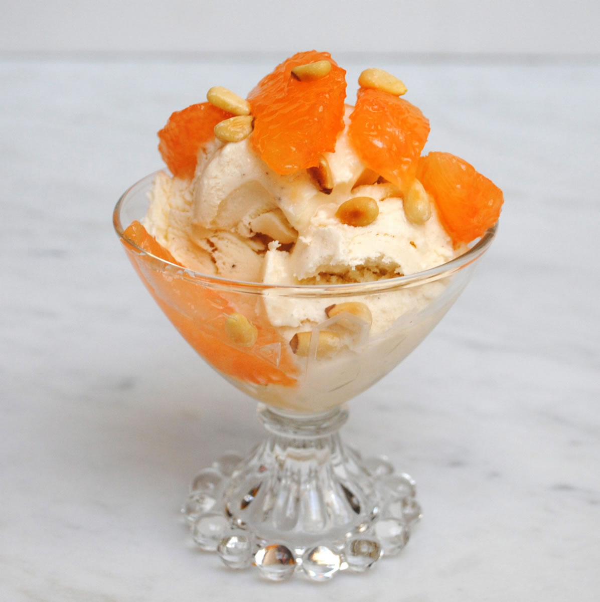 Top vanilla ice cream with some spiced grapefruit compote and a sprinkling of toasted pine nuts to make a winter sundae.