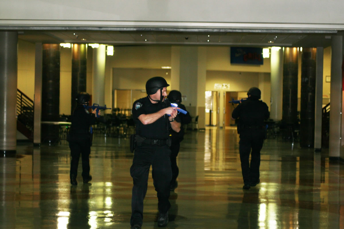 Camas police officers check CHS during a lockdown drill last Tuesday. They carried blue plastic gun replicas to add an element of realism.