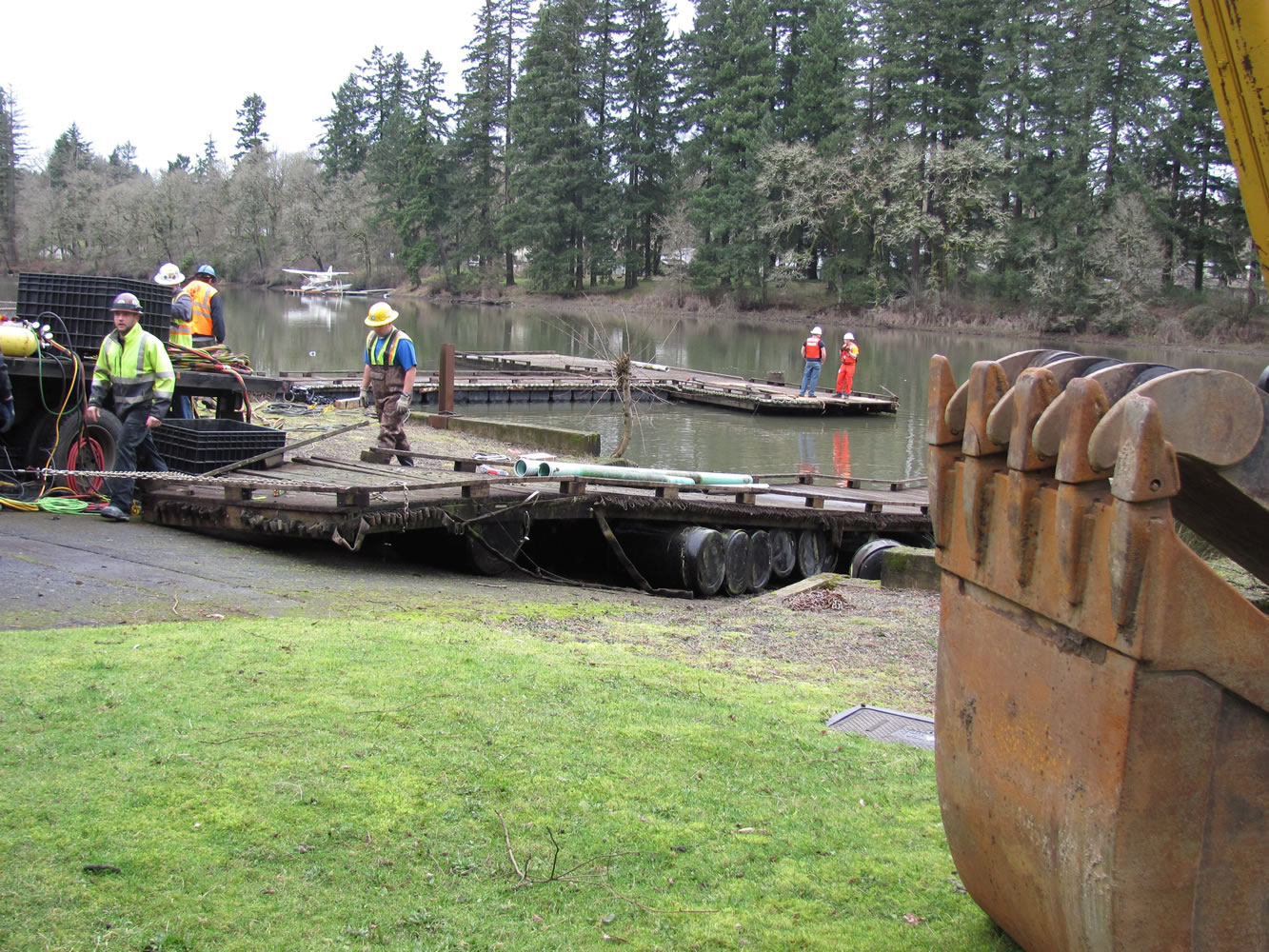 Crews from the City of Camas and Ballard Diving and Salvage work to pull a section of old dock from Lacamas Lake at the site of the former Moose Lodge on Friday. The wood and other debris were hauled away from the property yesterday for disposal. Four large logs, 6 to 7 feet in diameter, which were used as supports underneath the dock, were discovered.