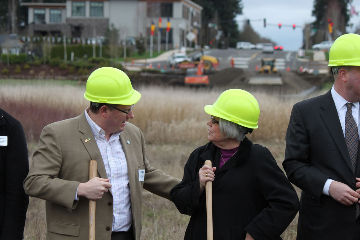 As excavating equipment hums in the background, government and business officials gathered for the ground breaking of the Northwest 38th Avenue/Southeast 20th Street extension project on March 5. Camas Mayor Scott Higgins (left) speaks with Shari Hildreth, deputy district director for U.S. Rep.