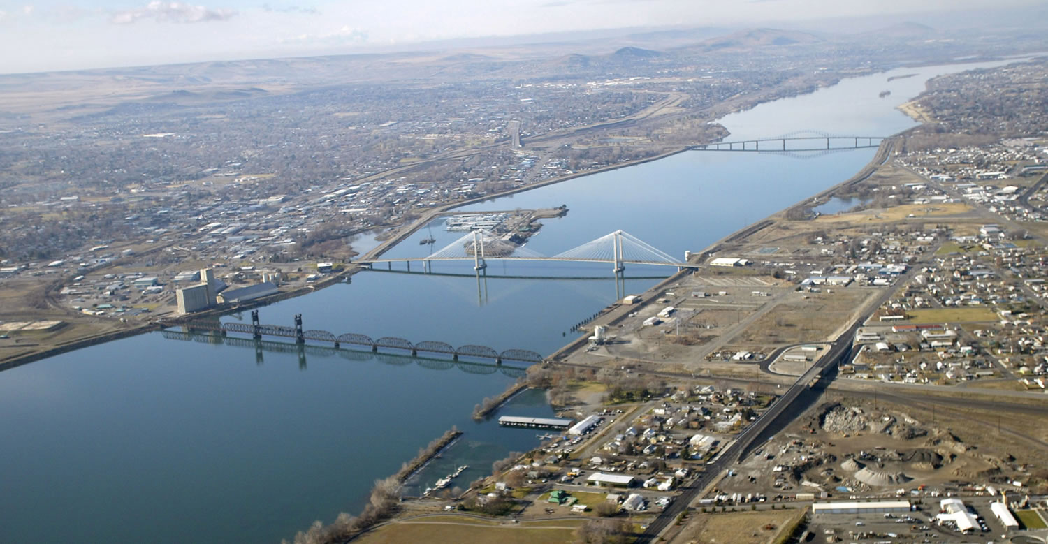 Tri-City Herald
An aerial view of the Columbia River and the cable and blue bridges that span it and link the cities of Kennewick and Pasco in Washington. Scientific models predict that rising temperatures will reduce the snowpack and glacier mass in nearby mountains, resulting in less water for the 1,243-mile-long Columbia River.