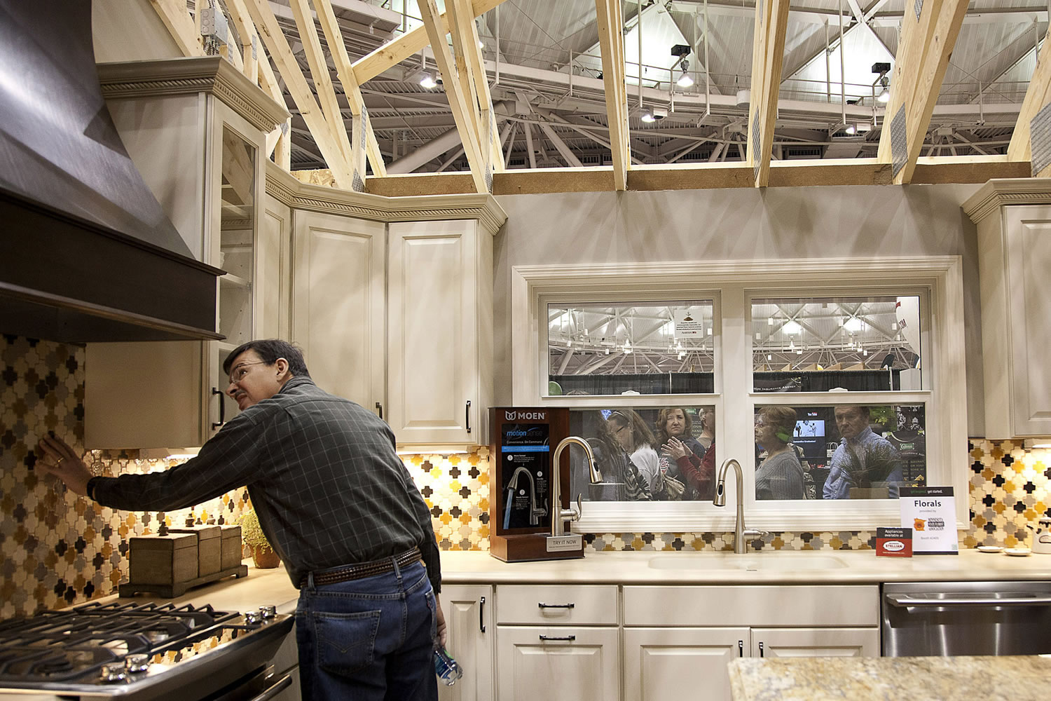 Ariana Lindquist/Bloomberg News
An attendee looks at a kitchen in an &quot;Idea Home&quot; at this month's Minneapolis Home &amp; Garden Show. Homeowners who did only must-do repairs or minor upgrades during the recent housing downturn are again starting wish-list projects as home prices rise.