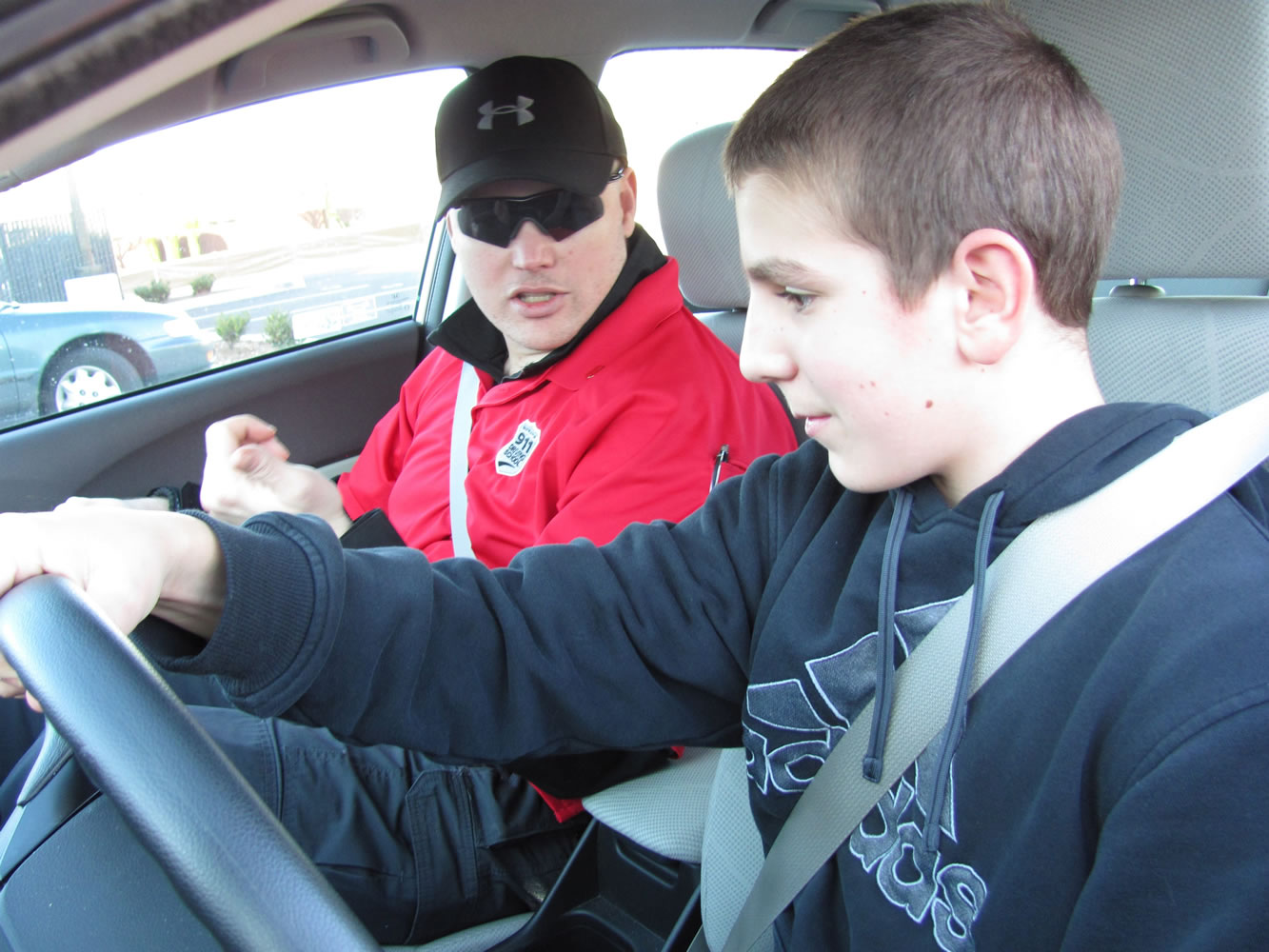 Geary Enbody, an instructor with the 9-1-1 Driving School in the 192nd Avenue Station, talks to Washougal High School freshman Brody Oberg. Enbody, an officer with the Woodland Police Department, is among the law enforcement personnel who serve as knowledge/skills examiners.