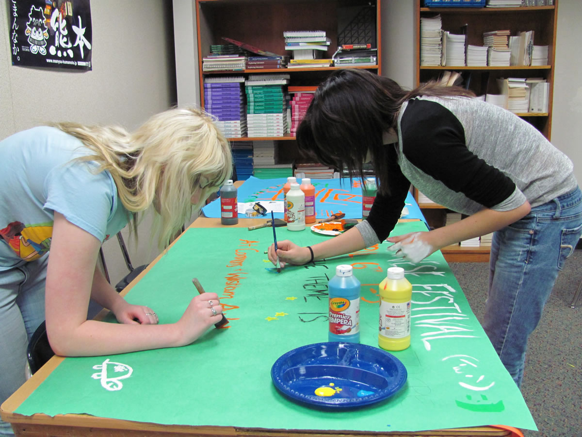 Noelle Schmidt (left) and Tess Russell put the finishing touches on a poster for the annual Japanese Culture Festival, held in the WHS commons on Saturday, April 6.