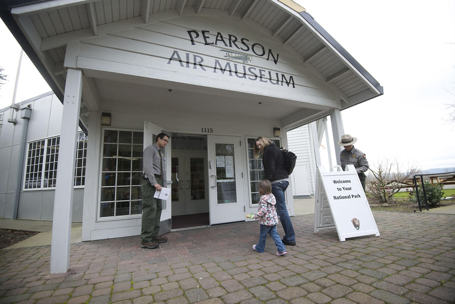 Aaron Ochoa, a National Park Service ranger, left, opens a door at the reopening of the Pearson Air Museum on Feb. 2, 2013.