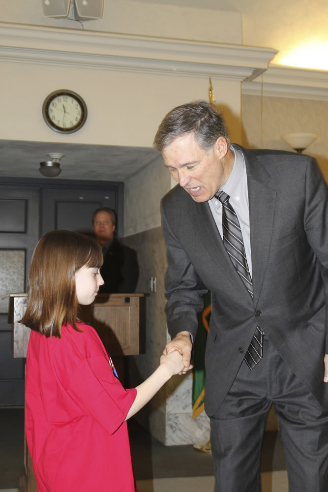 Paige Maas, a Hathaway Elementary School third-grader, shakes hands with Gov.
