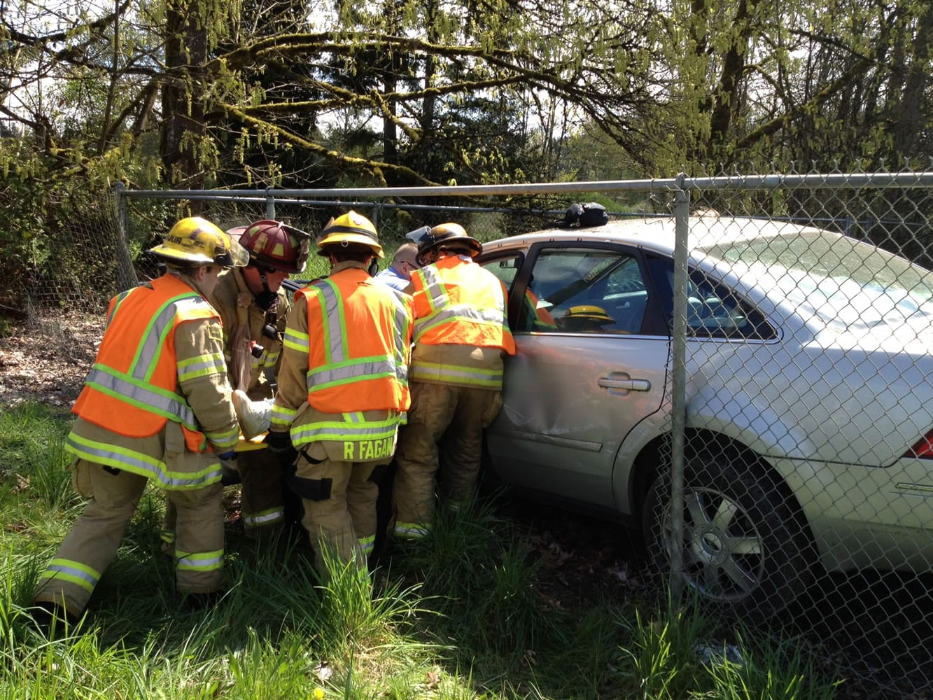Firefighters extricate an 84-year-old woman who lost control of her car around noontime Wednesday and drove through a fence.