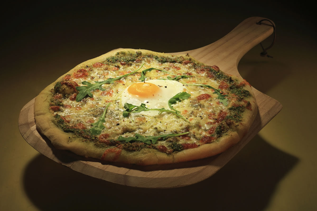 A breakfast-style pizza with a fried egg on top brings out the kid in us.