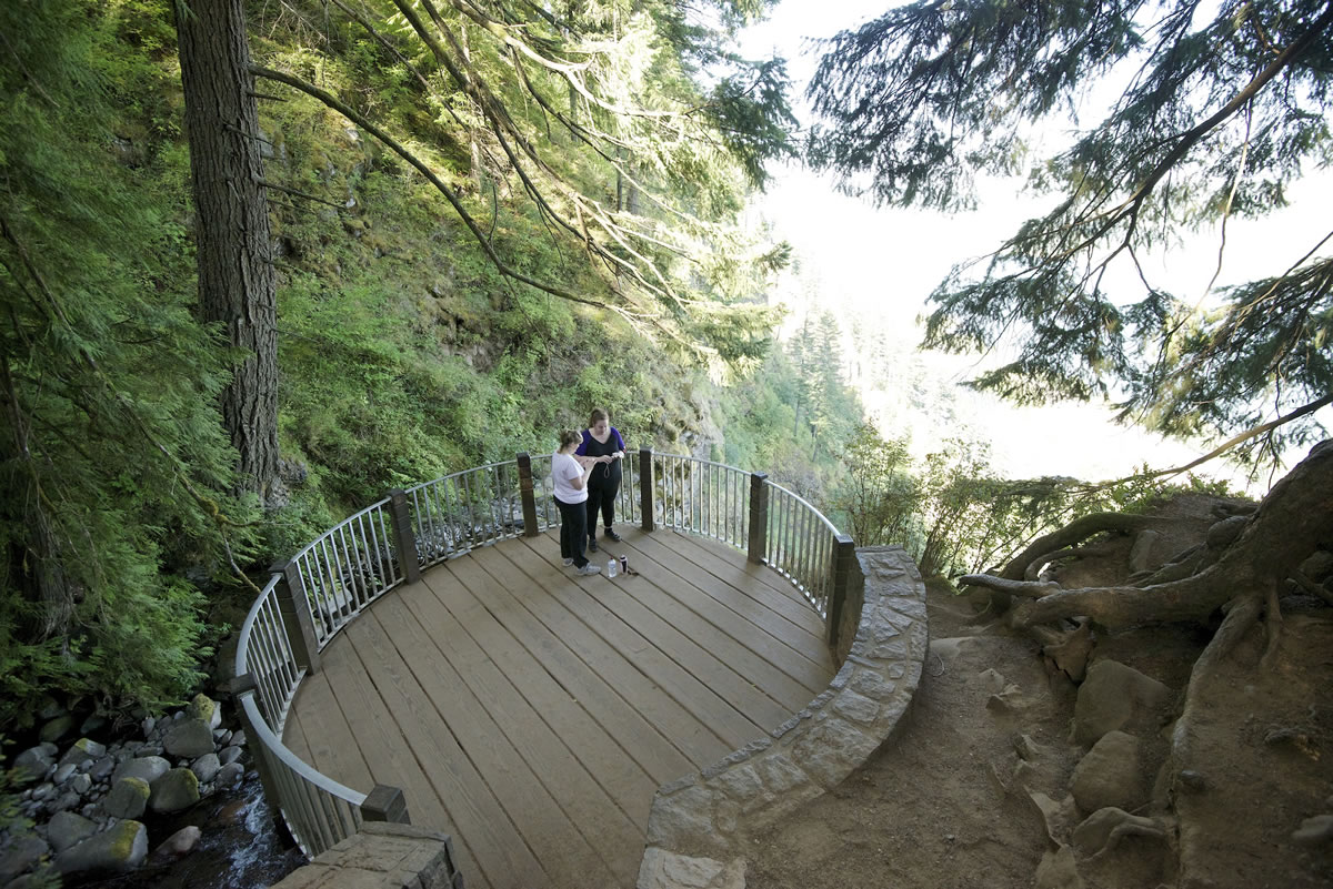 Women take photos at the top of the Multnomah Falls trail in the Columbia River Gorge.