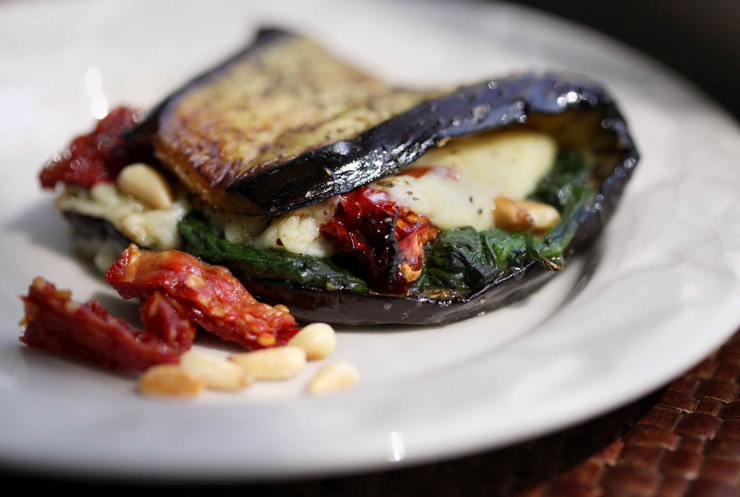 Fried eggplant slices can be made malleable and used to make a wrap with a stuffing of cheese, pine nuts, spinach and sun-dried tomatoes.