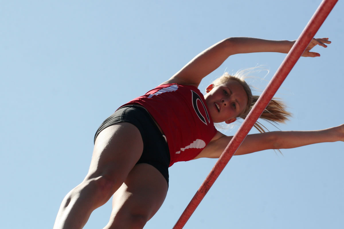 Caleigh Lofstead lets go of her pole vault after she clears the bar.
