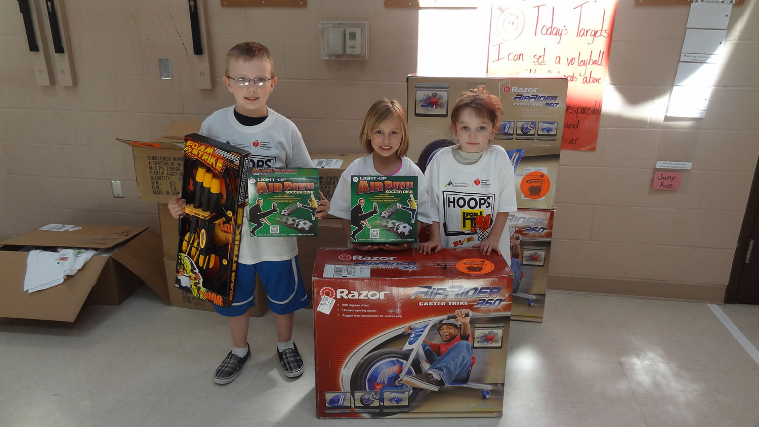 Third-grader Brian Hoff, kindergartner Addysen Case and first-grader Davlin Coburn proudly display the prizes they won for being top fundraisers during the Hoops for Heart event at Lacamas Heights Elementary School. A total of $10,925 was raised for the American Heart Association. Of that total, Coburn was the top fundraiser at $1,205.