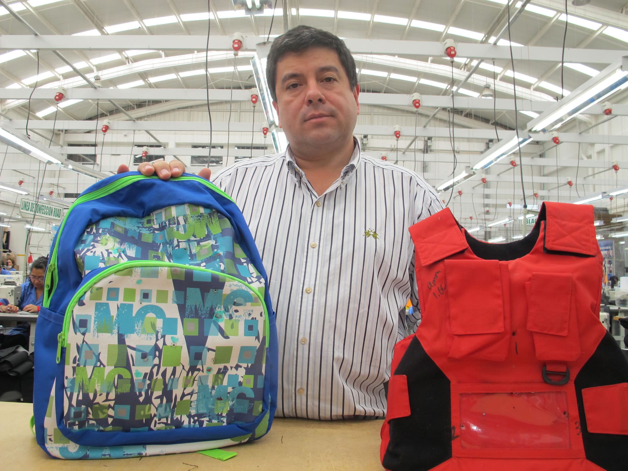 Clothing maker Miguel Caballero, know as &quot;the Armani of bulletproof clothing,&quot; holds two of his company's new products for American schoolchildren, a bulletproof backpack and vest.