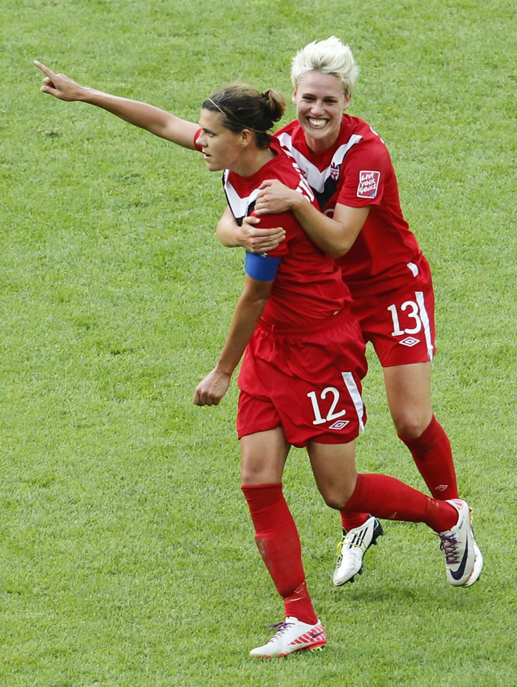 Canada's Christine Sinclair, left, is congratulated by her teammate Sophie Schmidt after scoring their side's first goal during the group A match between Germany and Canada at the WomenA-s Soccer World Cup in Berlin, Germany, Sunday, June 26, 2011.