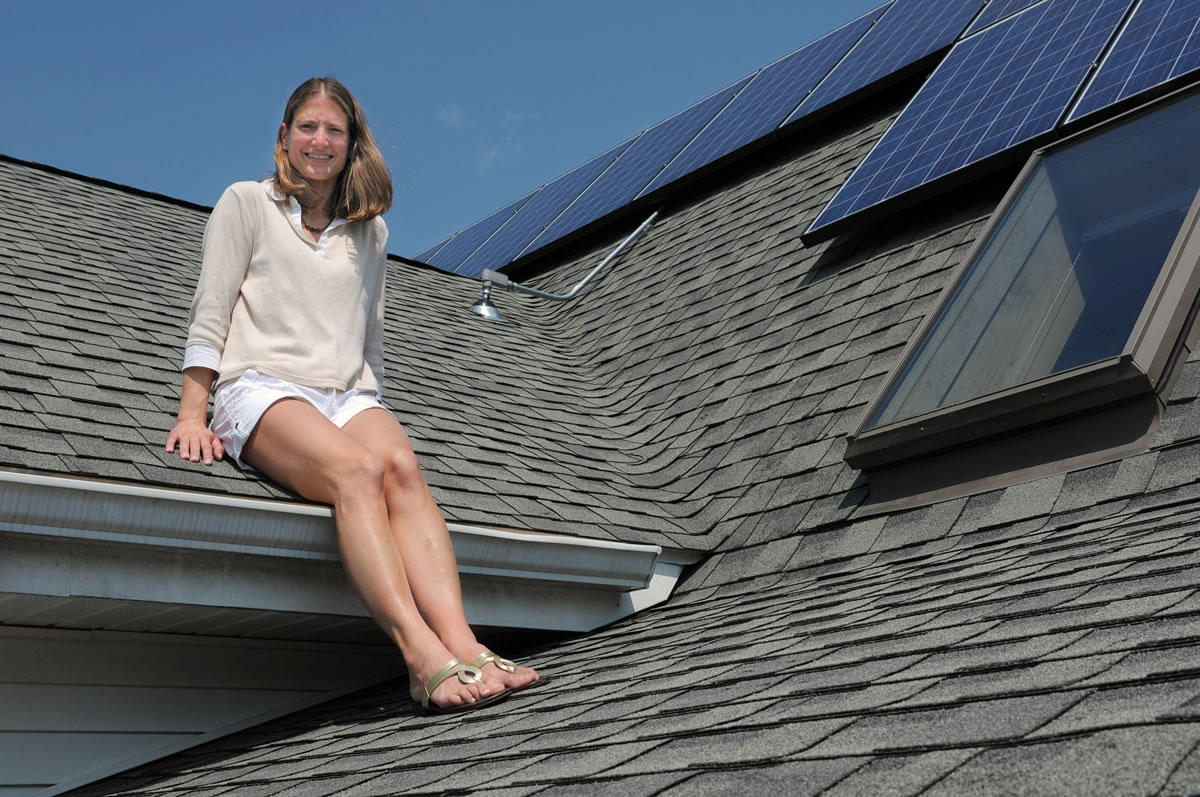 Melissa Pelchar sits on the roof of her Burlington, Conn., home in which she and her husband recently installed leased solar panels. Her husband said the couple paid $8,000 up front for the 20-year solar lease.