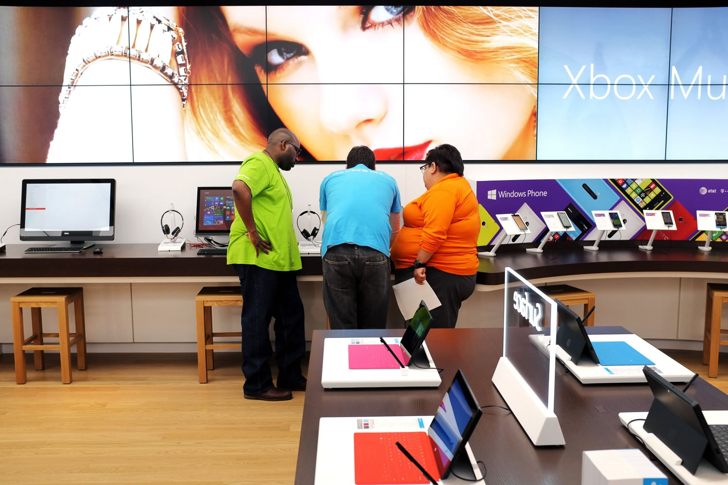 Employees Rico Price, from left, Matt Bastien and Bebe Gonzalez set up displays at a new Microsoft Store in St.