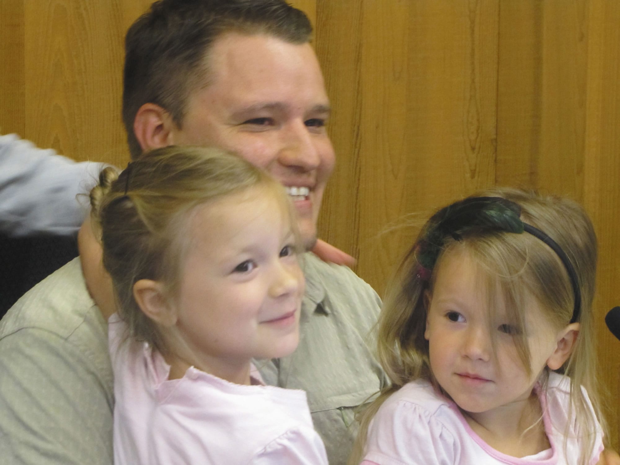 Jon Russell holds his daughters, Eve, left, and Emma, on Monday night inside the Washougal council chambers.