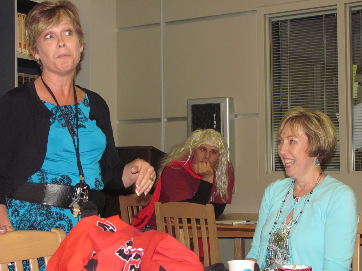 Camas High School librarian Rosemary Knapp (seated) listens to a funny story from career specialist Suzie Downs during her retirement party earlier this month.