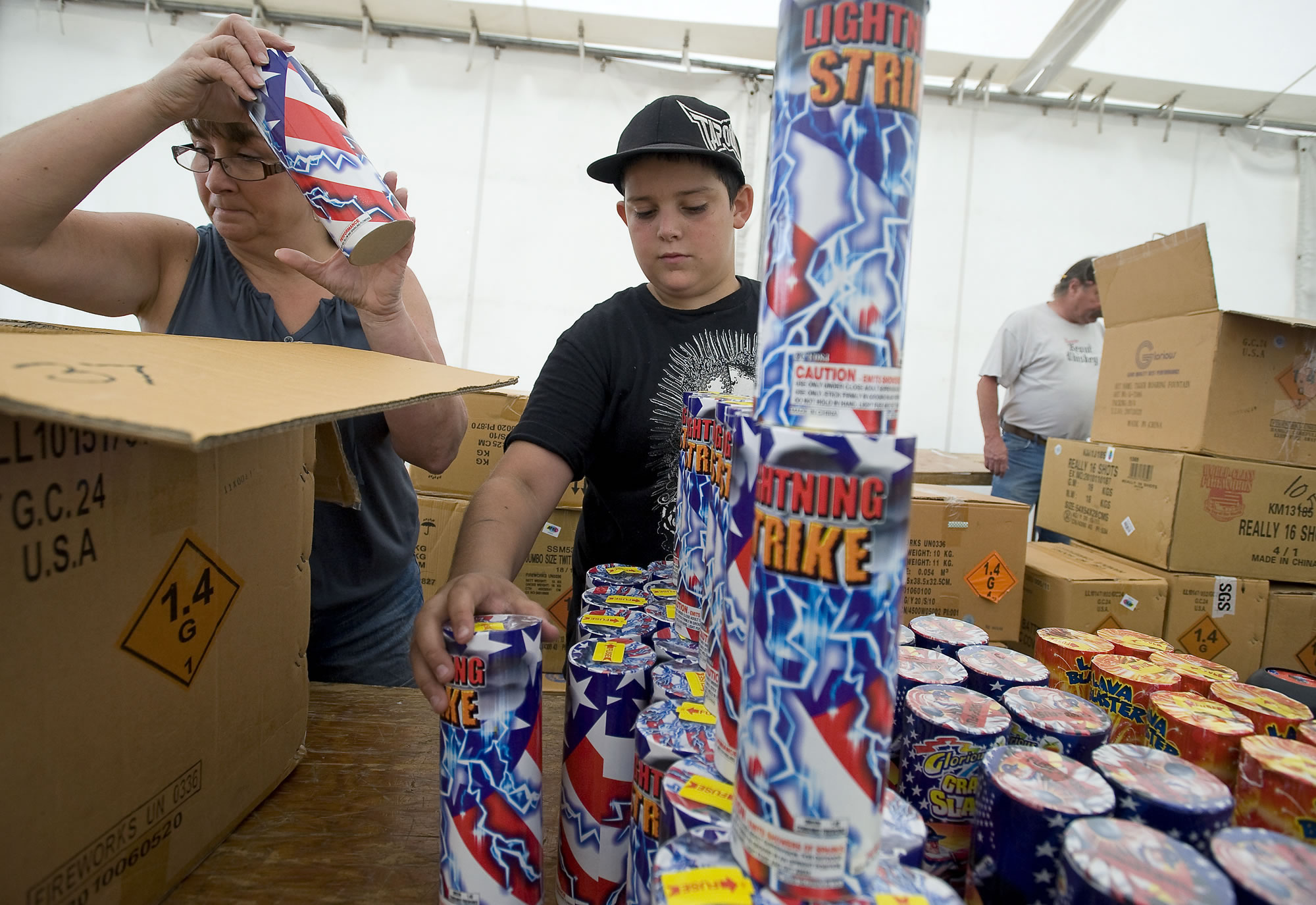 Jenifer Phillips of Vancouver and John Soares of Phoenix, Ariz., stock fireworks at the Wounded Warrior fireworks stand last year.