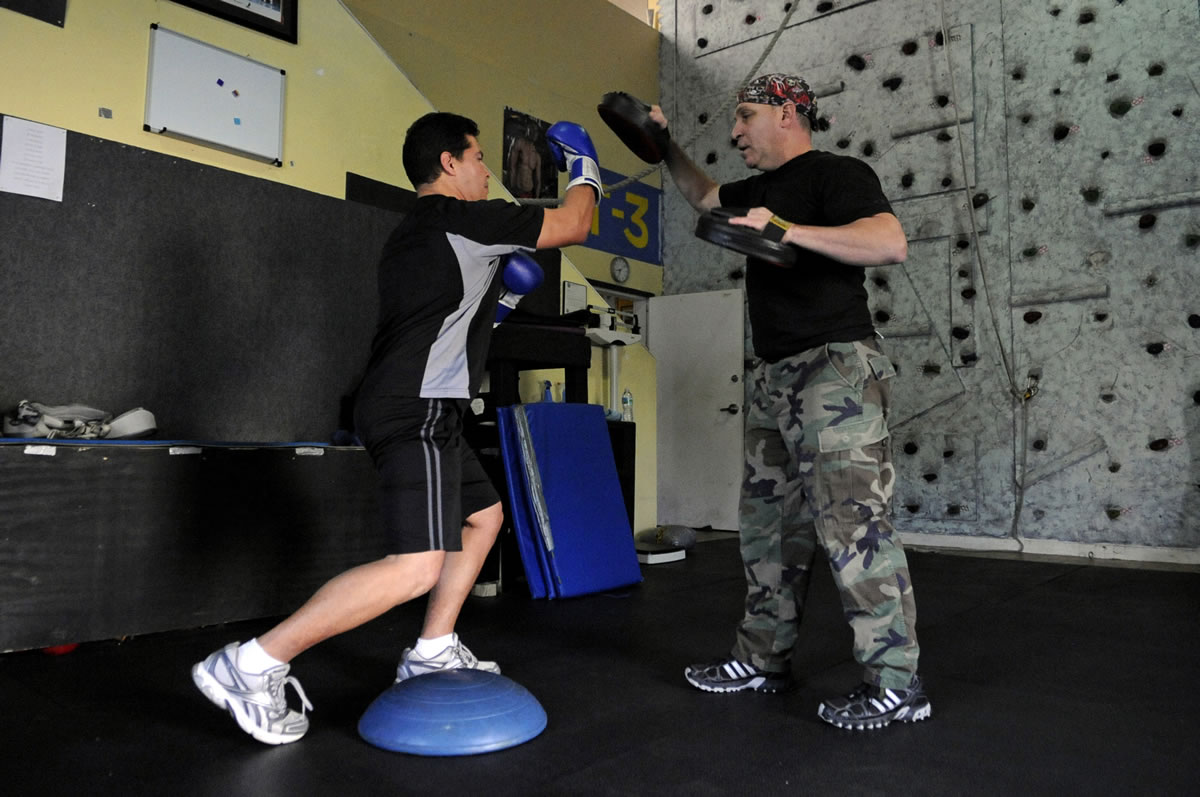William Defreitas, left, works out with trainer Craig Marks, of T3 Health &amp; Fitness, who uses boxing techniques as therapy for people with Parkinson's.