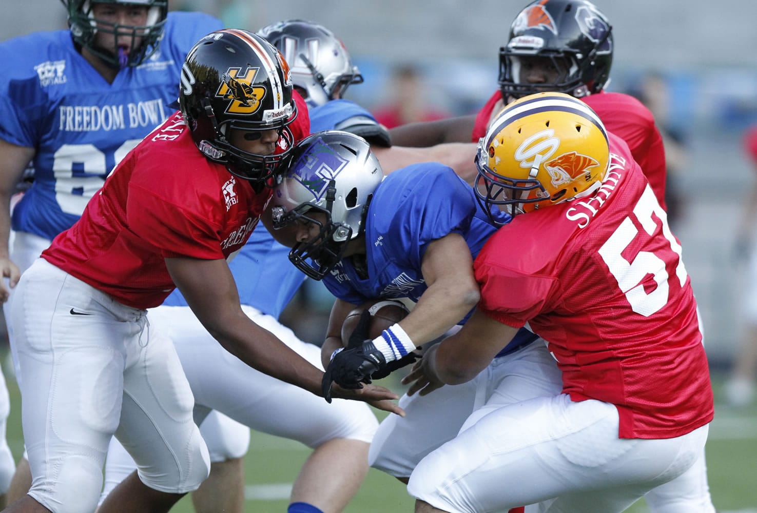 East running back Treve Ensley (center) of Union high school is tackled by West defenders at the Freedom Bowl at Kiggins Bowl.
