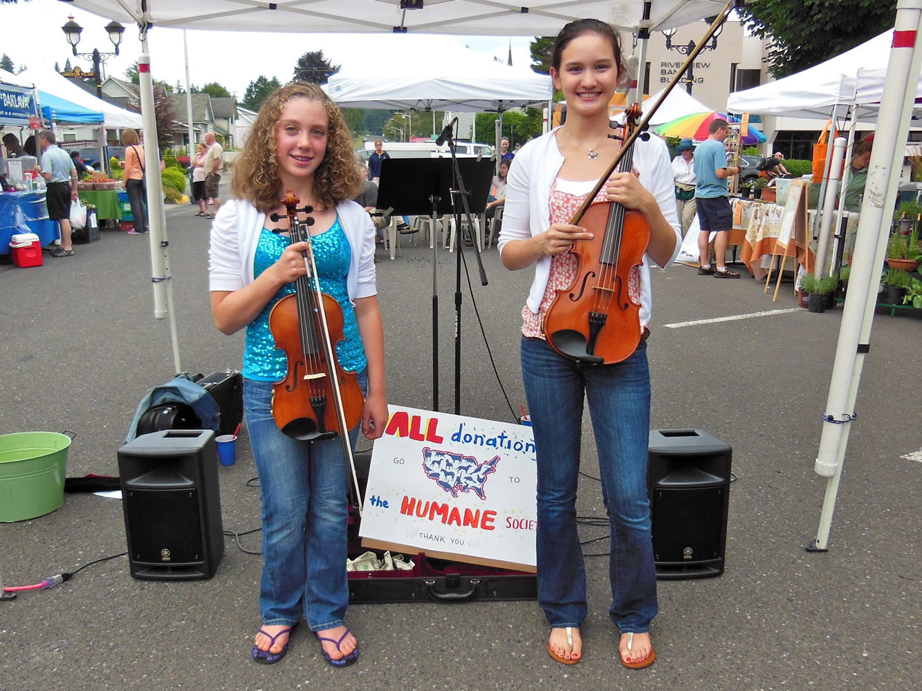 Sophia Hansen (left) and Rachel Greene played their violas at the Camas Farmer's Market last Wednesday to raise money for the Humane Society of Southwest Washington.