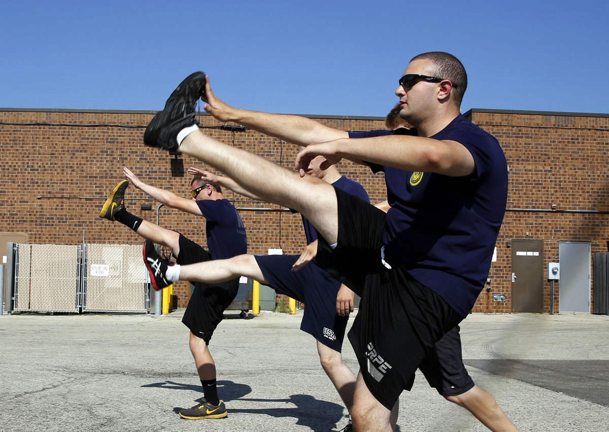 Herschel Gilbert, 20, right, leads three other future sailors in their daily physical training regimen July 17 at the Armed Forces Recruiting Center in Crystal Lake, Illinois.