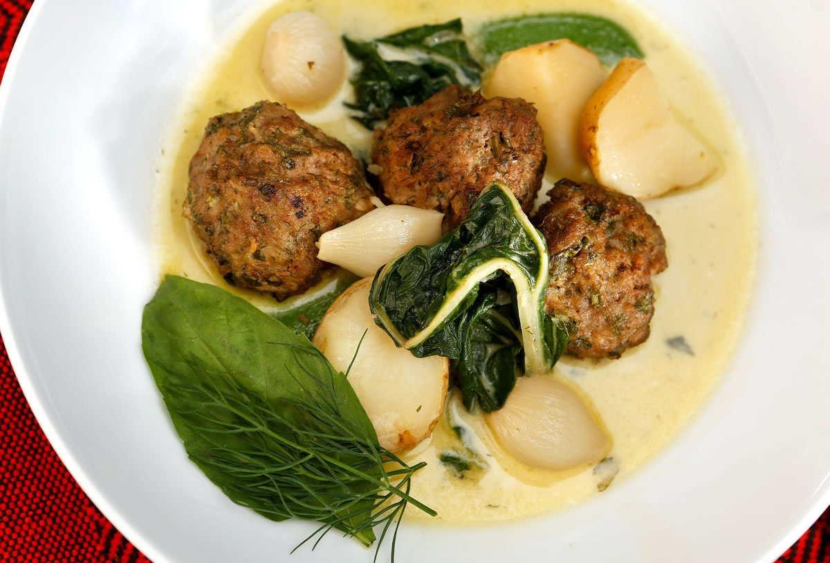 Meatball Haslama with Tahini Liaison should be served immediately in warmed bowls, garnished with a sprinkling of sea salt, fresh basil, dill and a drizzle of olive oil.