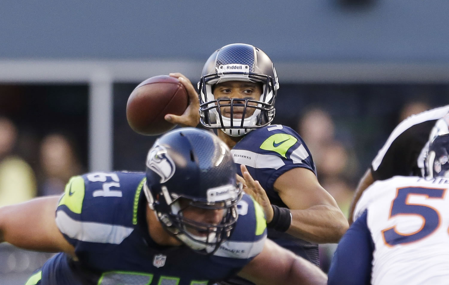 Seattle Seahawks quarterback Russell Wilson threw two touchdown passes against the Denver Broncos on Saturday in his first extensive preseason action.