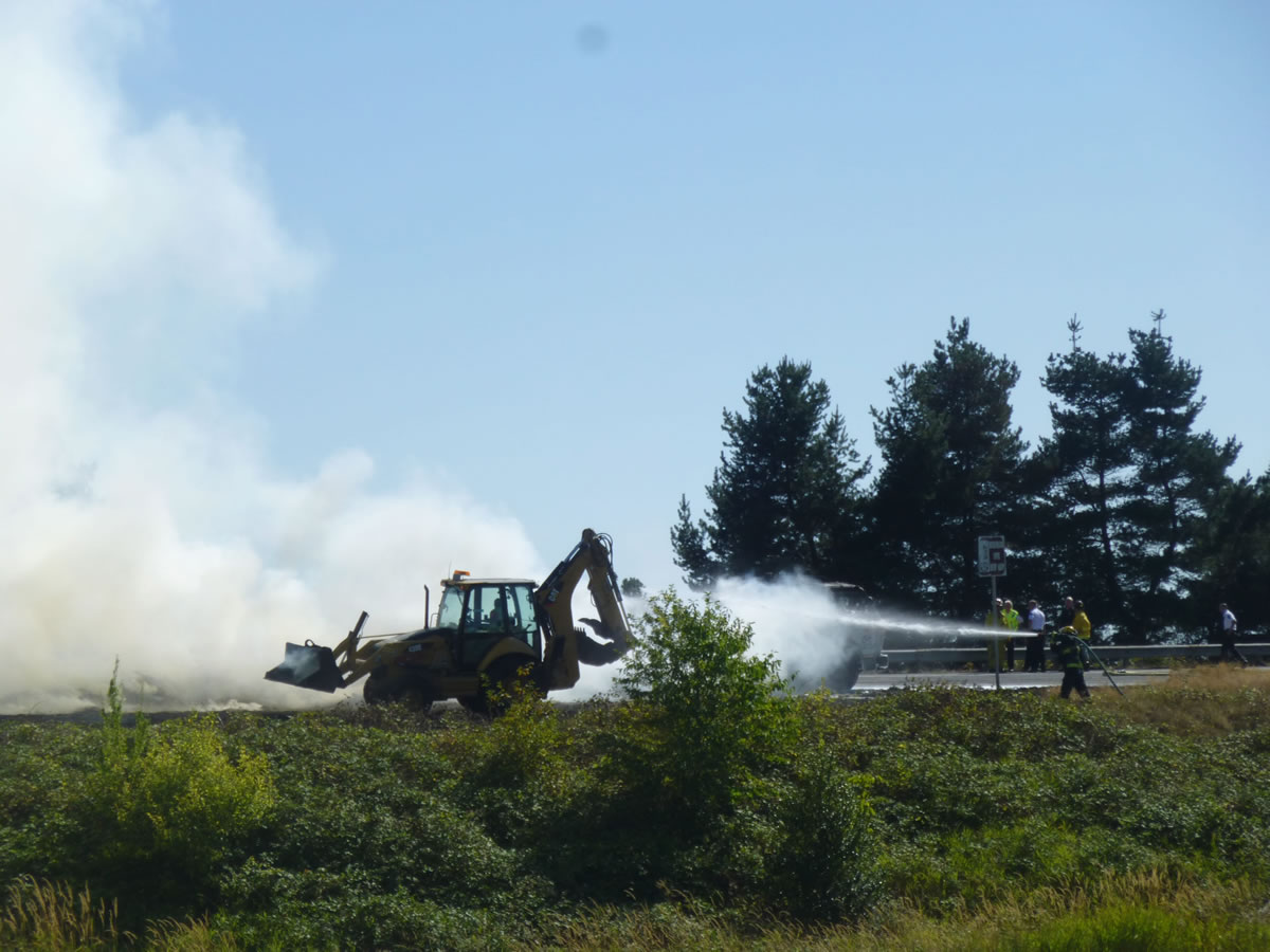 Firefighters work to extinguish a blaze after a truck carrying hay caught on fire on Aug.