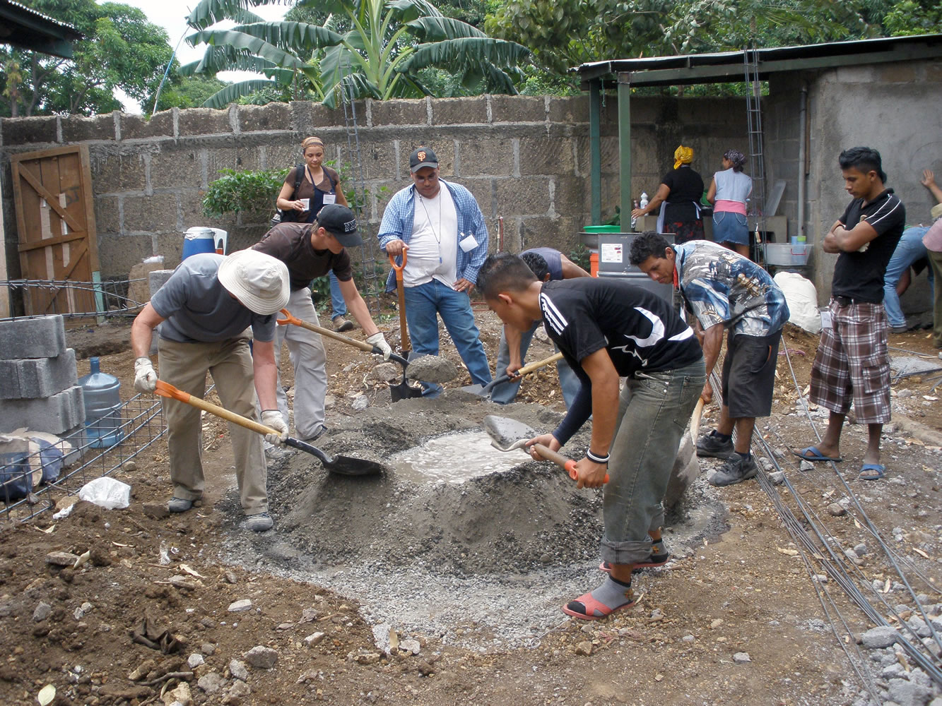 Side-by-side, members of the Gateway Community Church Nicaragua Mission Team and  residents of Tipitapa mix cement for the expansion of a church.