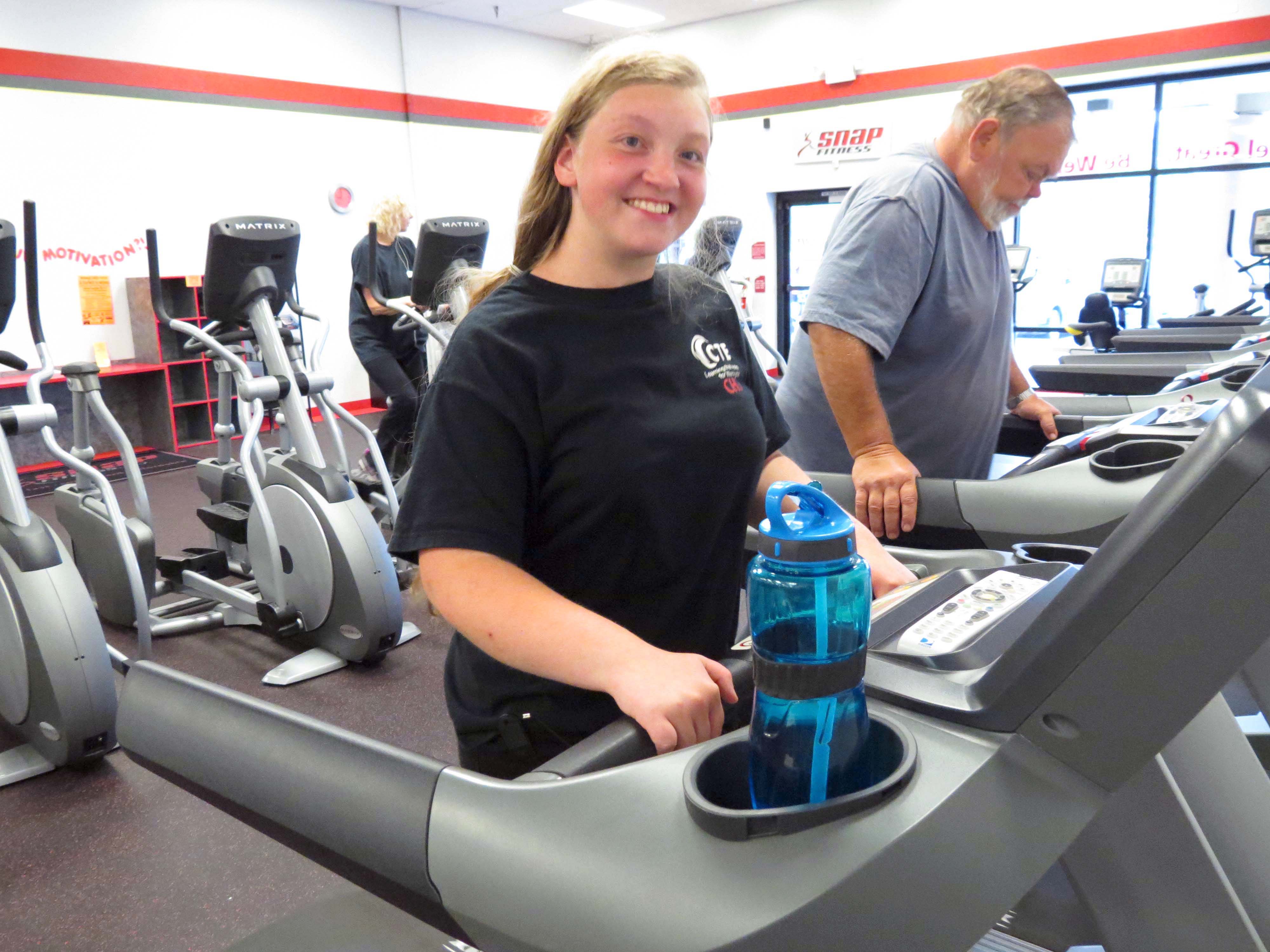 Mary McFarland of Camas (left) and Ron Winders of Washougal (right) build strength and endurance on the treadmills at SNAP Fitness in Camas. McFarland was born with a brain defect and had her hip replaced at the age of 13. Winders, 62, is going in for knee replacement surgery.