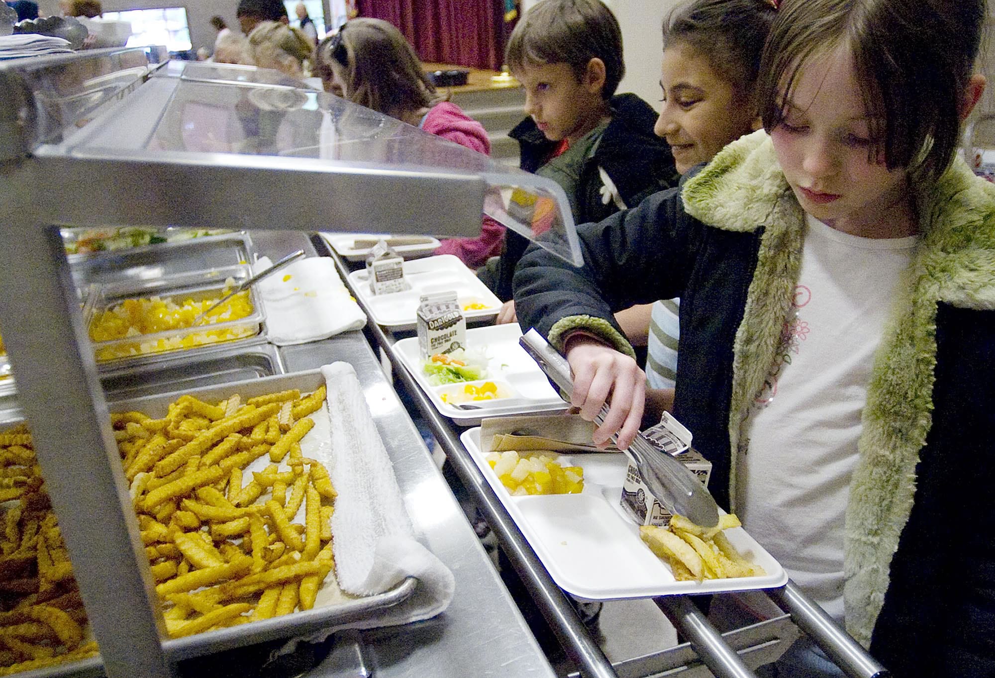 A student adds some French fries to her lunch tray. New U.S.