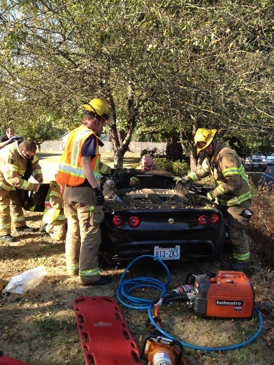 Firefighters had to cut the top off of a Lotus sports car when it drove up an embankment and crashed into a tree in Ridgefield on Wednesday afternoon.