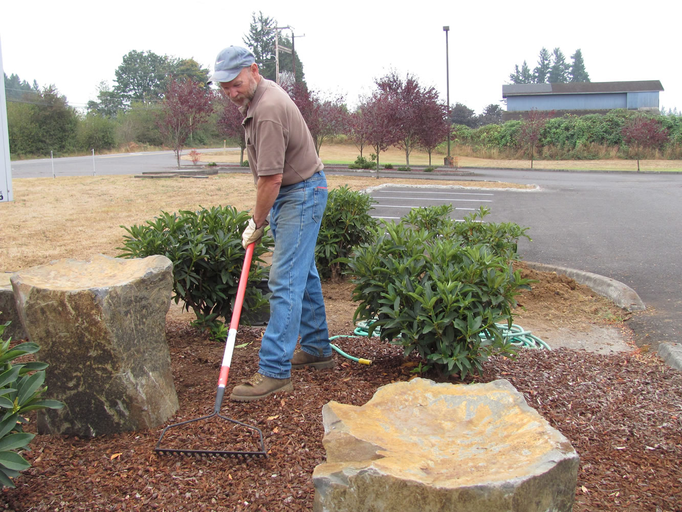 Steve Day, the financial administrator for NorthLake Church, works on the landscaping after shrubs and rocks were added near the entrance to the church. A new sign will be unveiled Saturday, during an open house and barbecue.