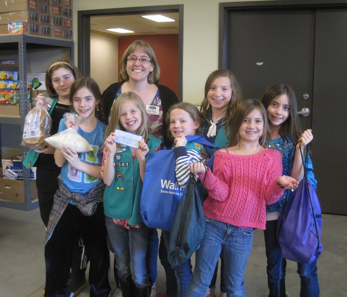Meadow Homes: Members of Vancouver Girl Scout Troop 42561 donate $506 on April 10 to the Share Backpack Program, which helps provide food to children in need. From left back: Maddy Surface, Becky Parker of Share, Lily Jonas, Kenna Yakimchick.
