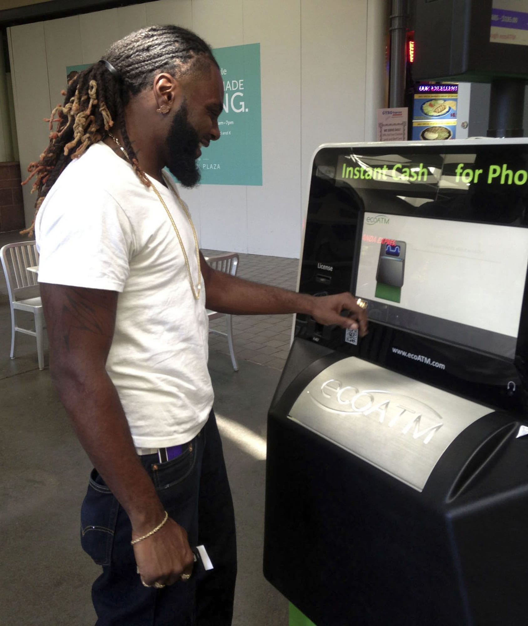 Marcellus Lang, a security guard at Old Sacramento sports bar, uses an EcoATM kiosk at Downtown Plaza mall to get instant cash for two devices: a used cellphone and an iPod Touch.