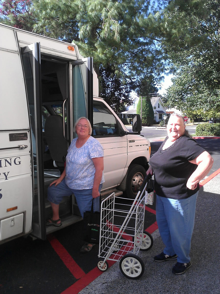 Columbia House residents Lorraine Harrington, center, and Darlene Pieper get on the Plan 770 van for a recent Farmers Market run.