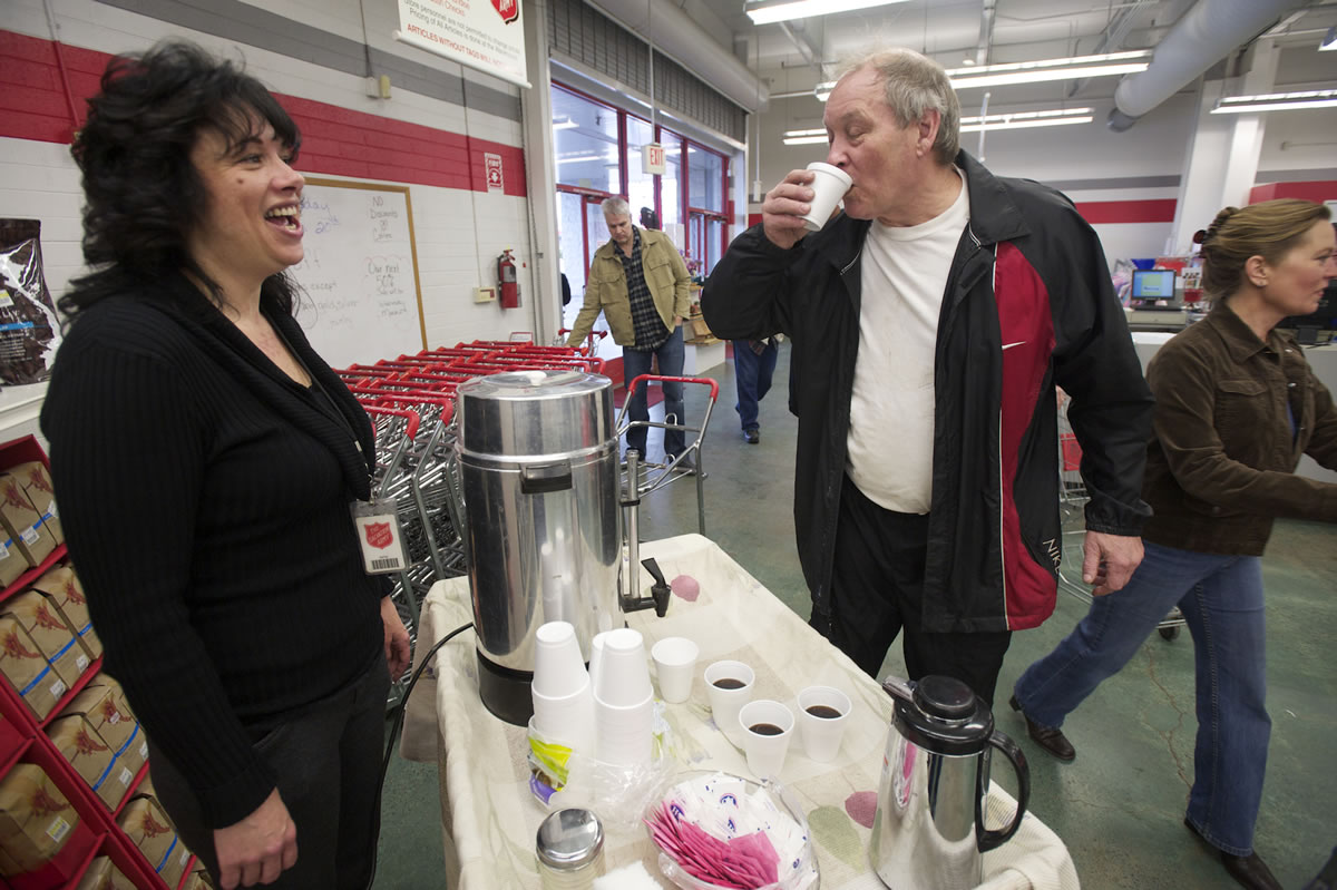Hazel Dell Salvation Army thrift store manager Laurie Hill serves customer John Scherger a free cup of coffee made with beans from Vietnam.