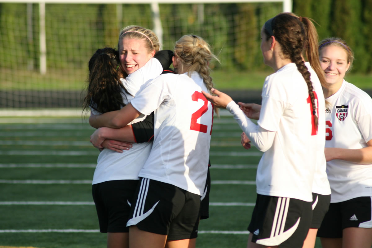 Camas High School goalkeeper Lauren Rood celebrates with her teammates after blocking three kicks by Mead in the shootout Saturday, at Doc Harris Stadium.