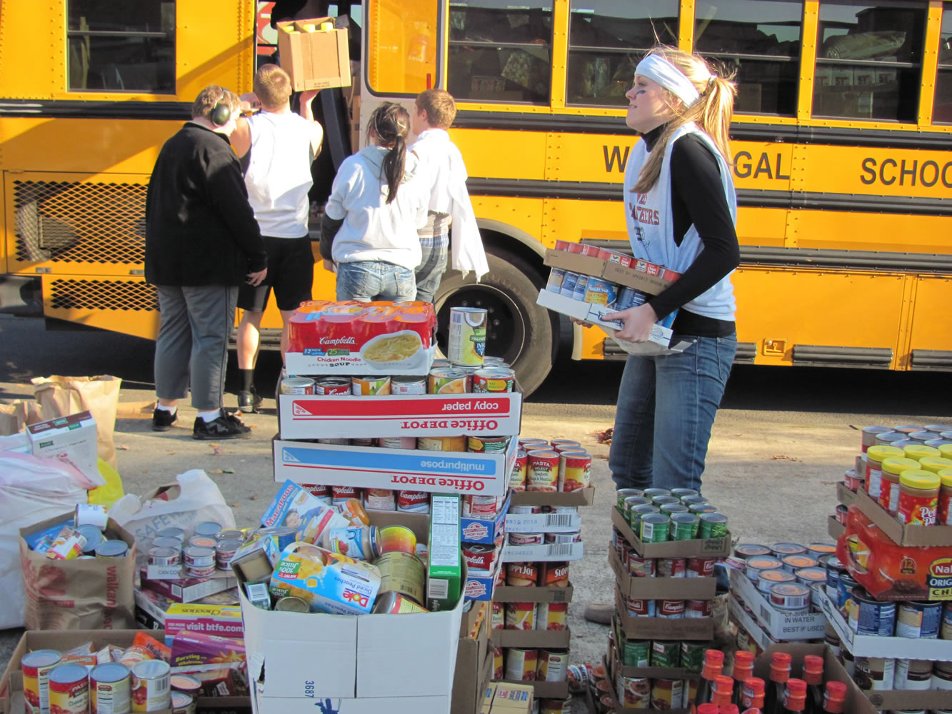 Students fill a school bus with non-perishable food items during last year's Stuff the Bus food drive, which generated 61,000 pounds of food.