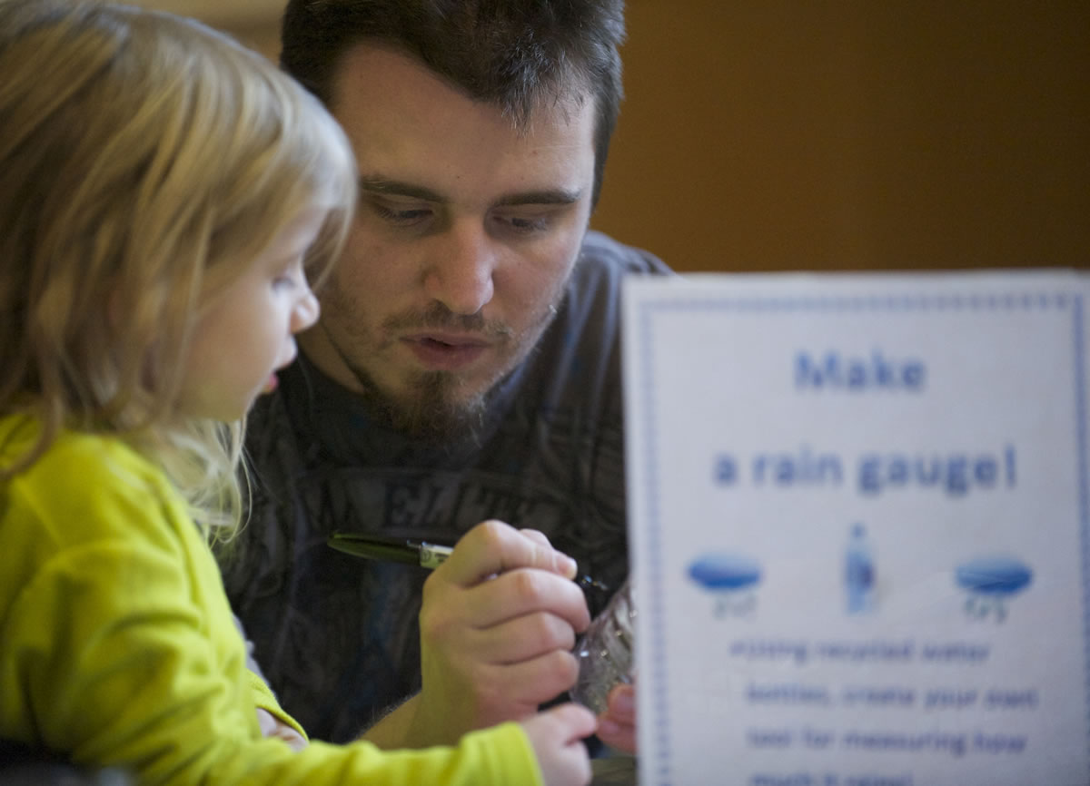 Erich Miller, 28, of Vancouver, helps his daughter Anaya, 4, make a rain gauge out of an empty water bottle at the Water Resources Education Center during an event to help children &quot;explore winter.&quot;