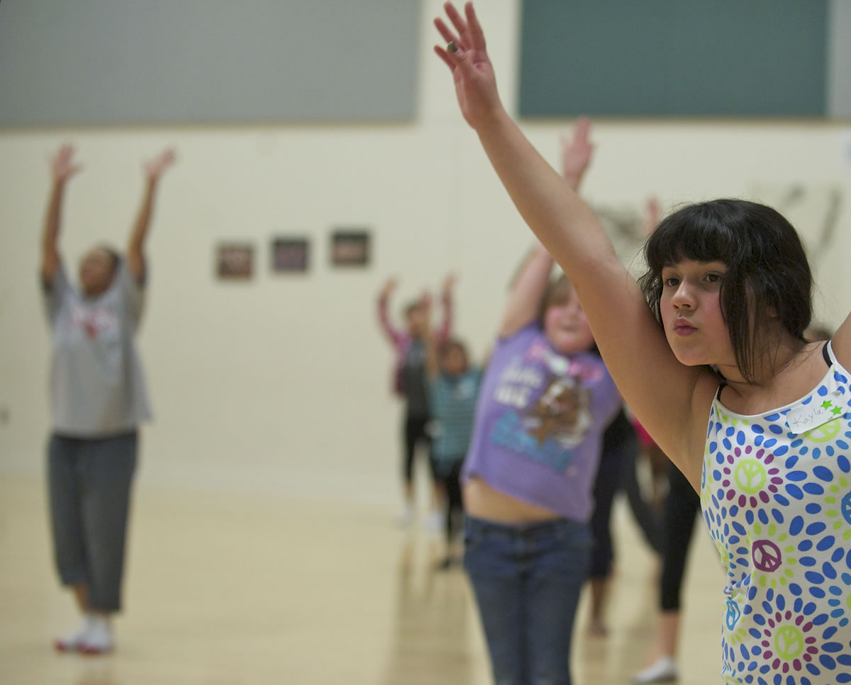 Kayla Banos-Arceo, 10, a student at Washington Elementary School, moves in a modern dance class led by Vancouver School of Arts and Academics teacher Fern Tresvan, background left.